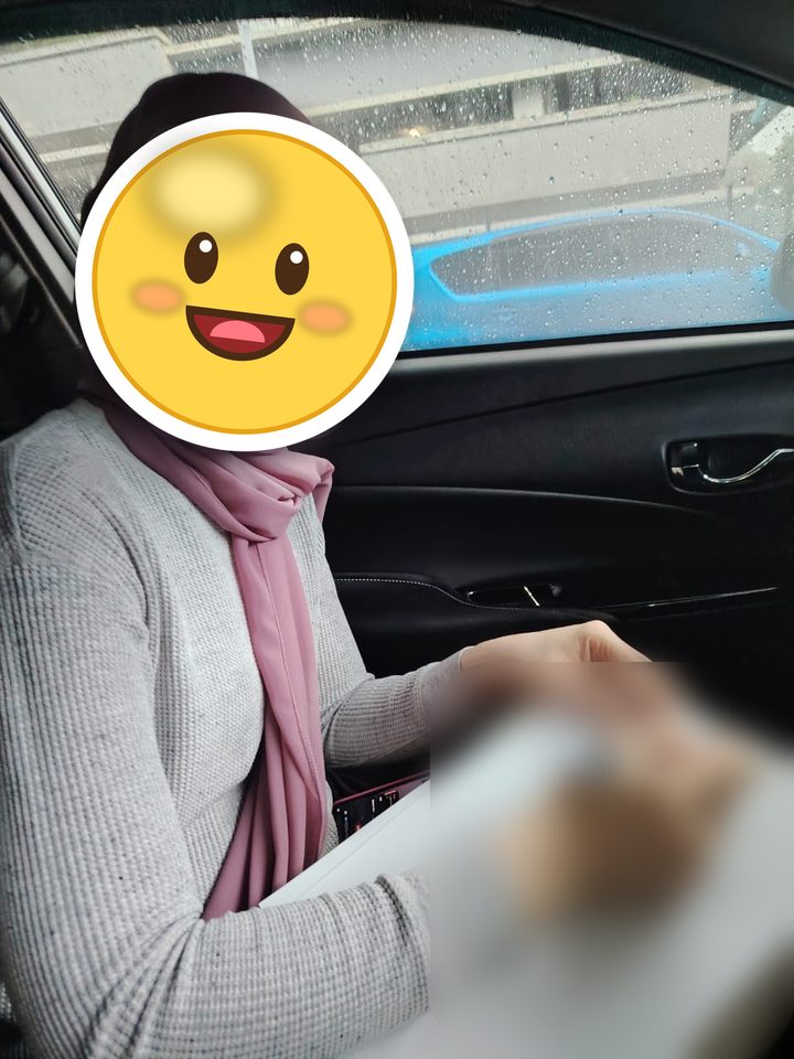 Pelanggan menandatangani borang di dalam kereta